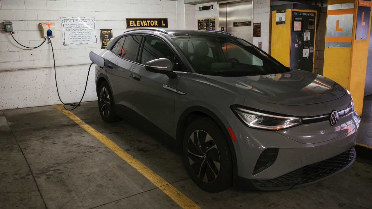 A Volkswagen ID.4 electric vehicle charges at an EV charging station.