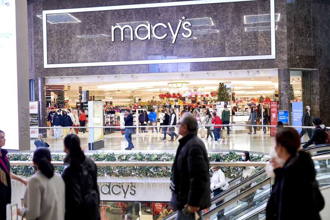 Shoppers pass a Macy's department store at the Westfield Garden State Plaza mall on Black Friday in Paramus, New Jersey, U.S., on Friday, Nov. 26, 2021.