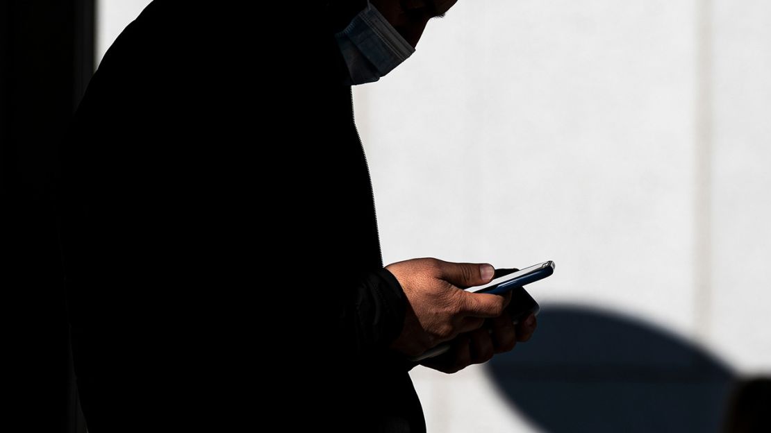 A pedestrian uses a smartphone in front of a store in Walnut Creek, California, in January 2022.